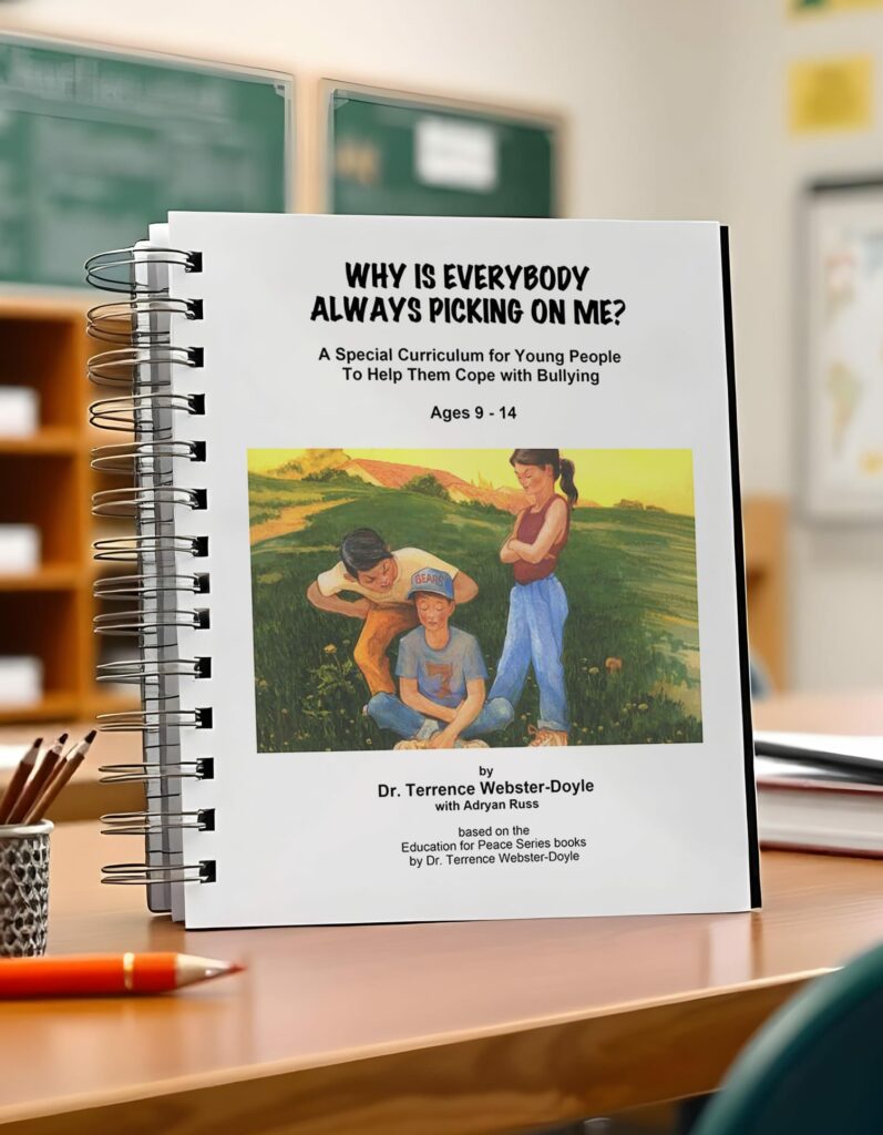 Spiral-bound book titled "Why Is Everybody Always Picking on Me?" a special curriculum for young people ages 9-14 to cope with bullying by Dr. Terrence Webster-Doyle, on a classroom desk.