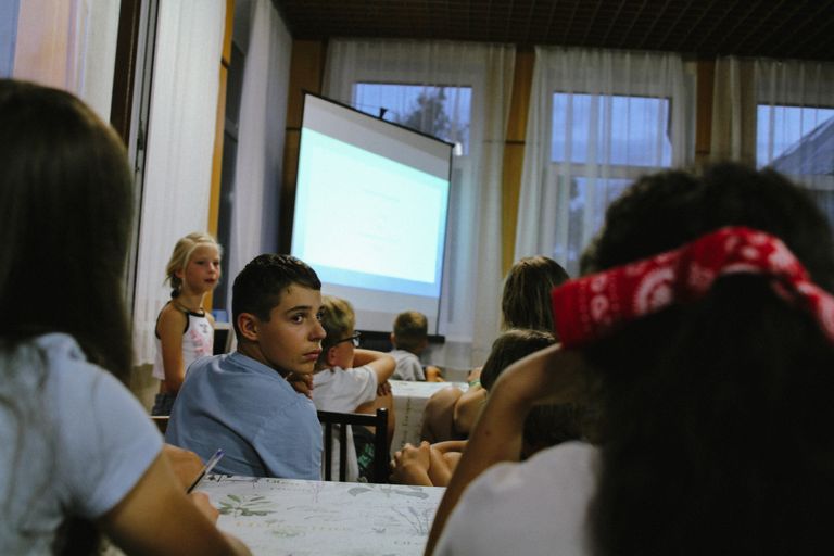 A group of kids attentively watching a classroom presentation indoors.